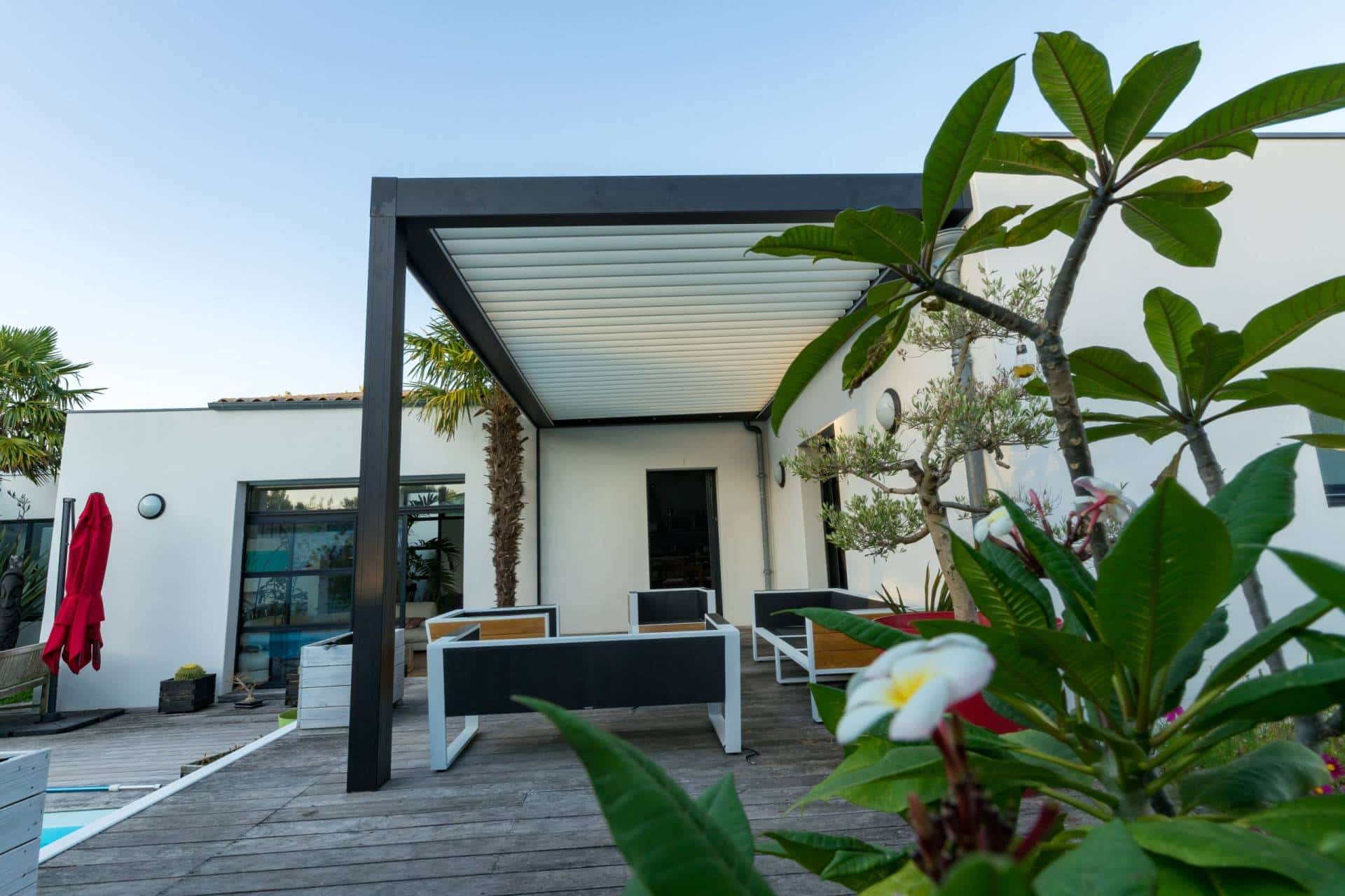 Pergola lamelowa nad tarasem z miejscem wypoczynkowym